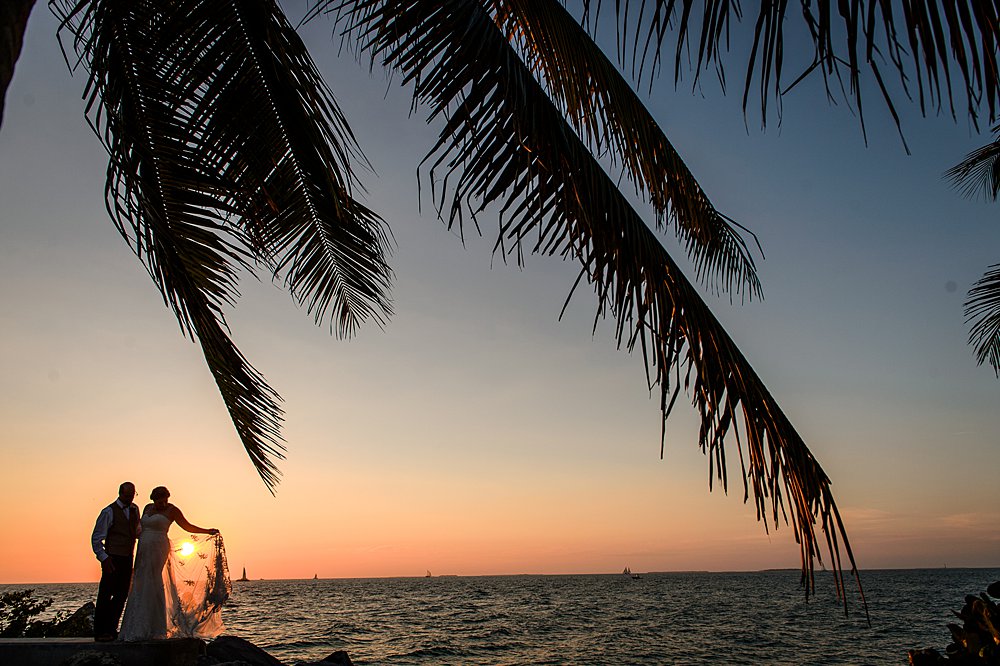 Wedding couple at sunset in the Florida Keys with a palm tree in the foreground
