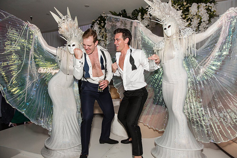 two men in tuxedos with costumed dancers at a wedding reception in the Florida Keys