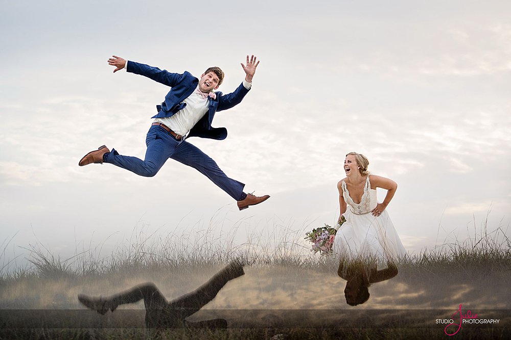 groom jumping in the air while the bride laughs