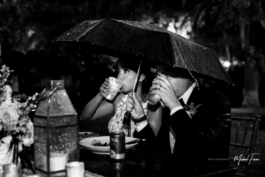 couple sipping cocktails under an umbrella during hurricane season